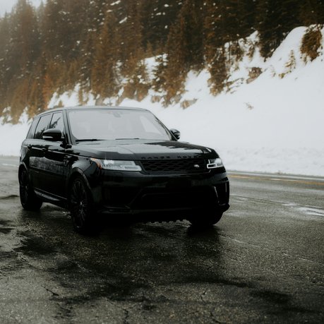 A black Range Rover Sport tackles a winter road.
