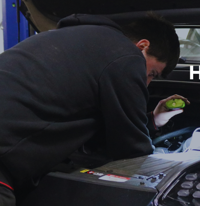 Image of technician working on car with Hyundai logo.