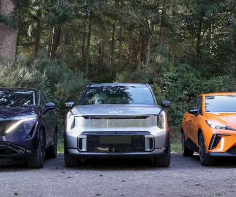 Image of three EVs from Nissan, Kia and MG lined up in a forest.