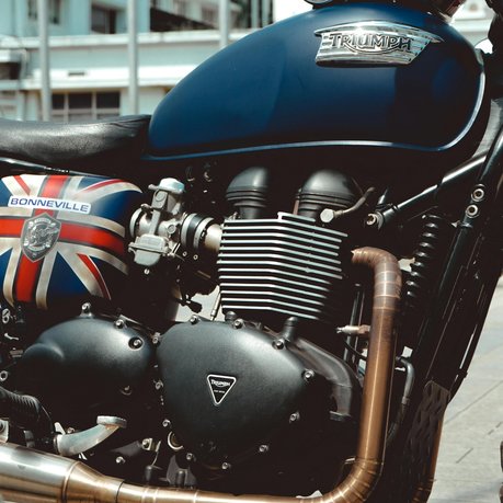 A Triumph Bonneville with a retro helmet resting on the tank.