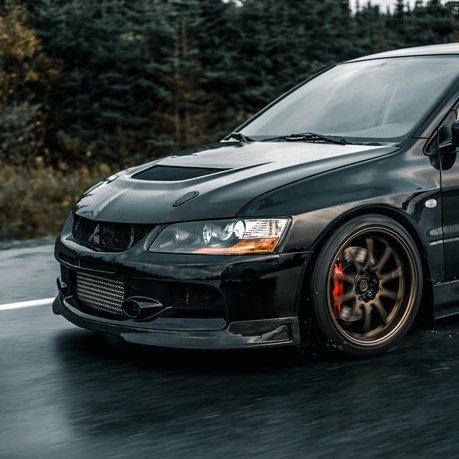 A black Mitsubishi Evolution X being driven on the road.