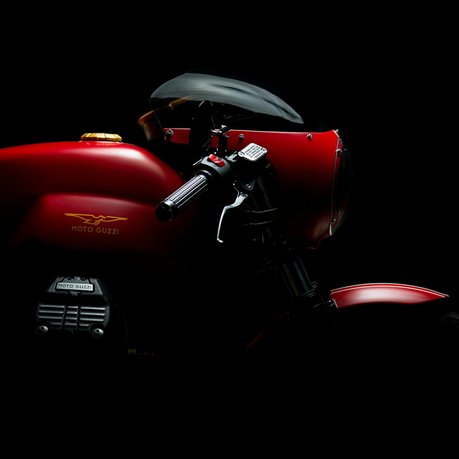 A red Moto Guzzi motorcycle with a very dark background.