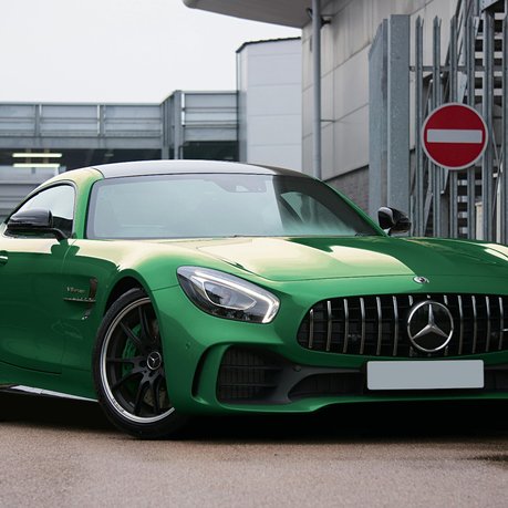A Merecedes-AMG GT in Green outside a showroom.