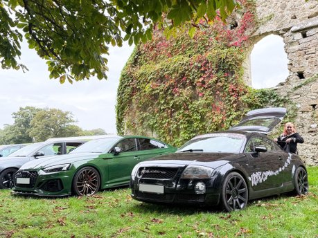 Green Audi RS and black Audi TT parked beside historic stone ruins at Beaulieu Motor Museum during Simply Audi 2025.