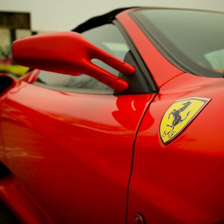A close up of a Ferrari wing showing the iconic badge clearly.