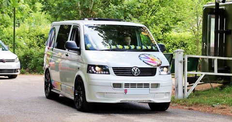 Custom white VW Transporter van entering the showground at Simply VW 2025 in Beaulieu.