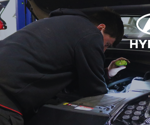 Image of technician working on car with Hyundai logo.