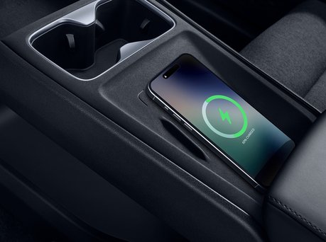 Image of phone wireless charging inside car.