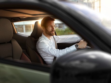 An image of a man inside the Suzuki e Vitara, looking at the rear-view camera display.