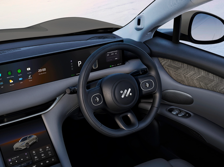 Image of driver's seat with display and steering wheel.