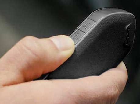 Image of someone pushing down on car key.